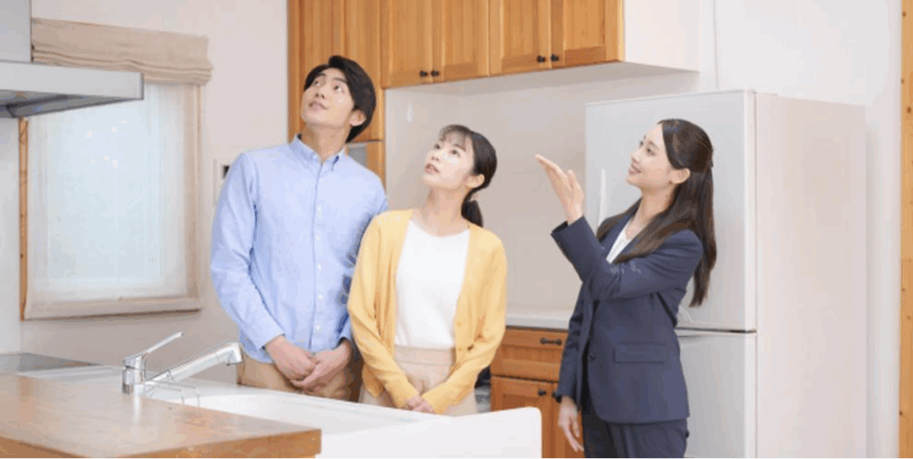 不動産の内見で説明を受ける若いカップルと営業担当者