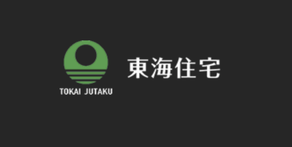 東海住宅のロゴマークと社名、黒背景に白文字と緑のシンボル