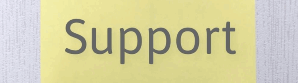 黄色い紙に書かれた『Support』の文字、木目調の背景