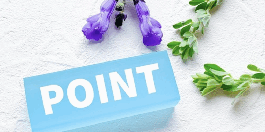 青い板に白文字で「POINT」と書かれた表示と紫の花
